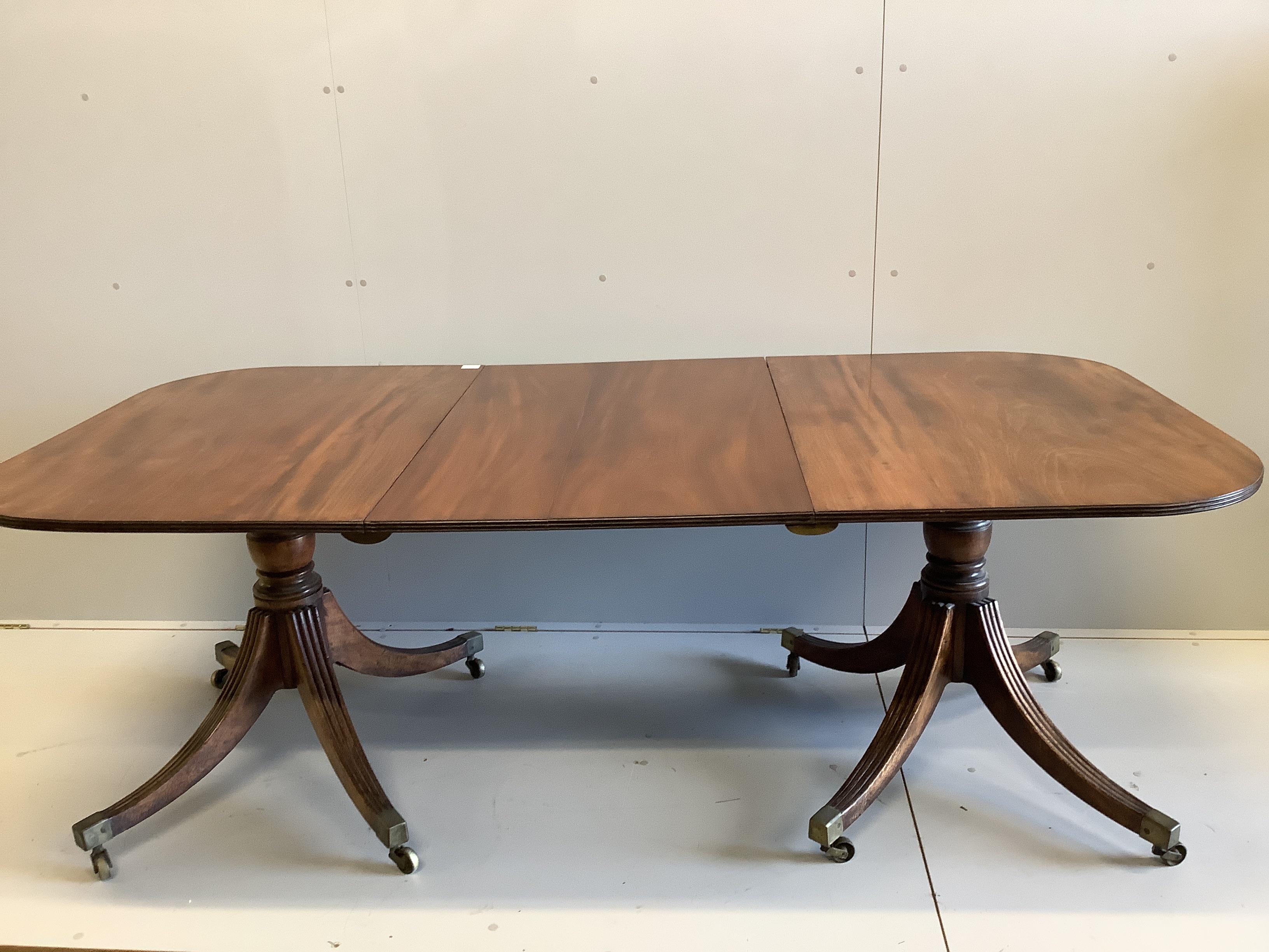 A Regency mahogany two pillar dining table, with one spare leaf. Length 206cm extended, depth 107cm, height 72cm.